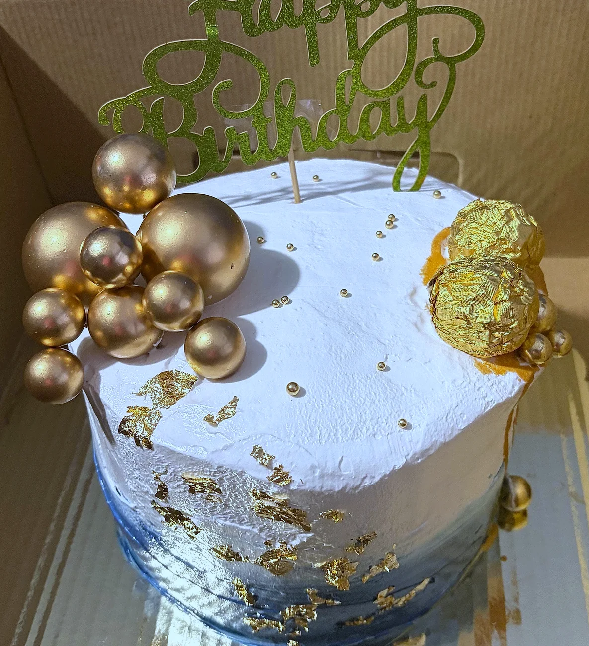 Pastel dorado con detalles azules y esferas doradas